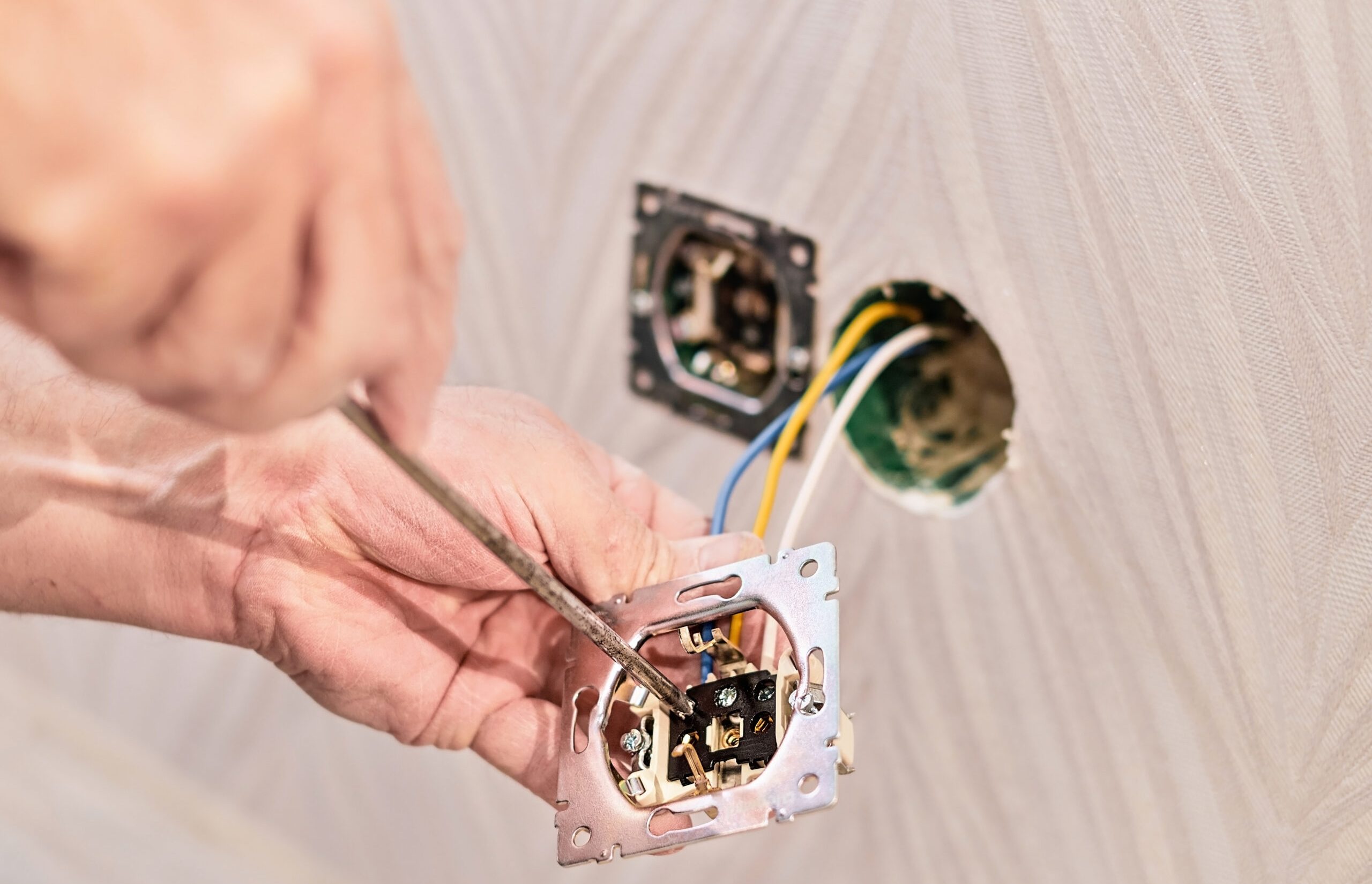 homem consertando uma tomada eletrica
